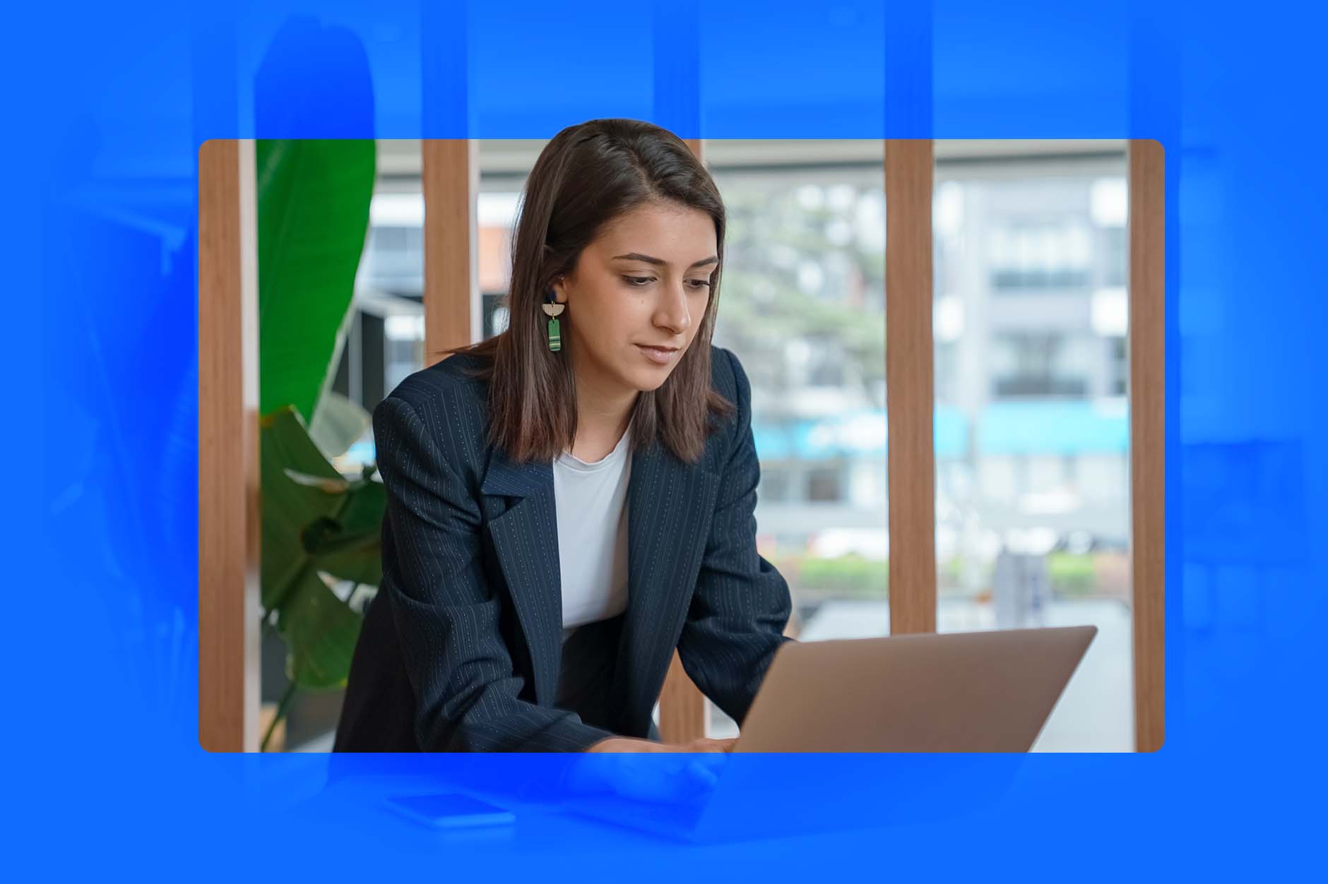 A woman dressed in business clothing at her laptop